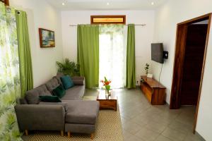 a living room with a couch and a tv at Maison d'hôte Chez Vané in Sambava