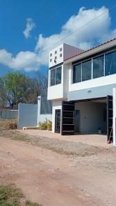 a white building with a garage on a dirt road at Cuarto en casa de campo in Arandas