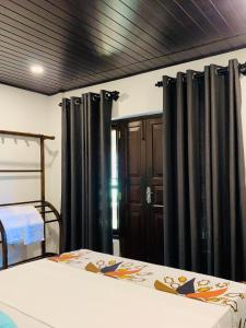 a bedroom with black drapes and a bed at D2 Villa in Tangalle