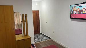 a living room with a television and a room with a hallway at Hotel Te Bakja in Tushemisht