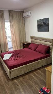 a bedroom with a large bed with red pillows at Hotel Te Bakja in Tushemisht
