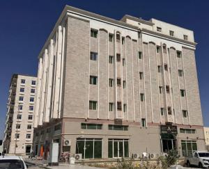 ein großes Backsteingebäude mit Fenstern an einer Straße in der Unterkunft أجاويد لشقق المفروشة 1 Ajaweed Residence in Salalah