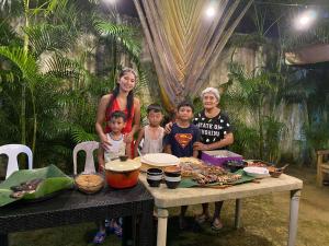 a family posing for a picture at a table with food at Naybe's Room rentals in Dapa