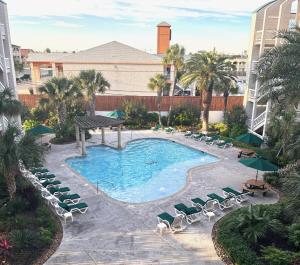 an overhead view of a pool with chaise lounge chairs and a resort at Boltons Bungalow Casa Del Mar in Galveston
