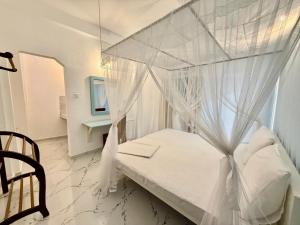 a bedroom with a canopy bed with white curtains at Shells Unawatuna in Unawatuna +36 photos