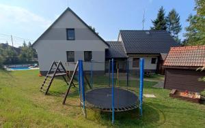 a playground in a yard in front of a house at Apartmány Anna s welness in Trojanovice