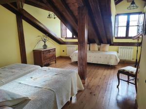 a bedroom with two beds in a attic at Apartamentos El Caballar in Sandoñana