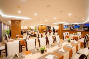 a banquet hall with tables and chairs and a man in the background at P Quattro Relax Hotel in Wadi Musa
