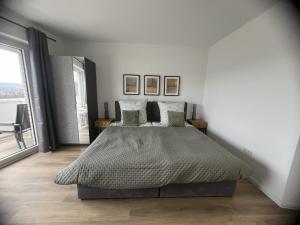 a bedroom with a bed and a large window at Bella Vista Studio-Appartement in Bad Rothenfelde