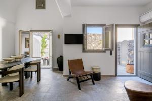 a dining room with a table and chairs at Koniko Santorini Private Pool Villas in Vóthon