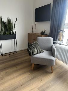 a living room with a chair and a flat screen tv at Bella Vista Studio-Appartement in Bad Rothenfelde