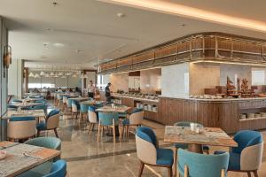 a restaurant with tables and chairs and a kitchen at Apec Mandala Ocean Retreat- Mui Ne in Mui Ne