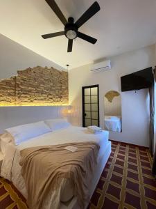 a bedroom with a large bed with a ceiling fan at Casa Zoé Hotel Boutique in Villeta