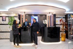 a man and a woman standing at a counter in a lobby at P Quattro Relax Hotel in Wadi Musa +82 photos