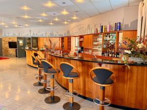 a bar in a restaurant with stools at Turmhotel Schwedt in Schwedt +46 photos