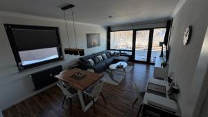 a living room with a couch and a table at Teufelsberg Panorama mit Sauna und Bergblick in Langelsheim