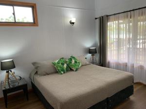 a bedroom with a bed with two pillows on it at Cabañas Raupa in Hanga Roa
