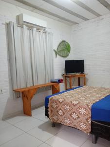 a bedroom with a bed and a desk and a television at Casa das Gaúchas in Canoa Quebrada +37 photos