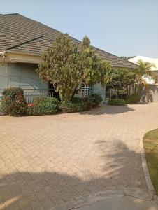 a house with a tree in front of a driveway at Andweruth Residences in Abuja