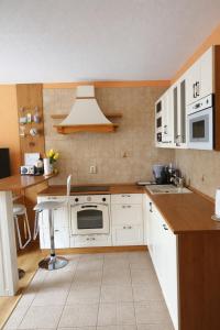 a kitchen with white cabinets and a stove top oven at Apartmán Levice in Levice +4 photos