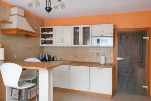 a kitchen with white cabinets and a wooden counter top at Apartmán Levice in Levice