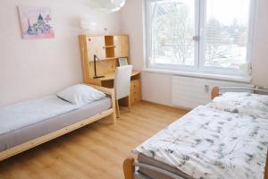 a room with two beds and a desk in it at Apartmán Levice in Levice