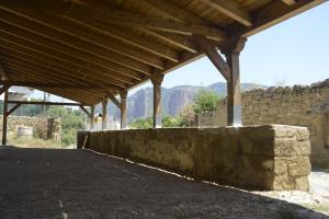 a building with a stone wall and a wooden roof at Hotel rural reina Berta in Murillo de Gállego
