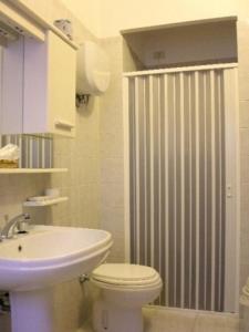 La salle de bains est pourvue de toilettes, d'un lavabo et d'une douche. dans l'établissement Hotel Belvedere, à Assise