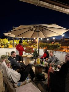 a group of people sitting around a table under an umbrella at Casa ZANATE in Guatemala