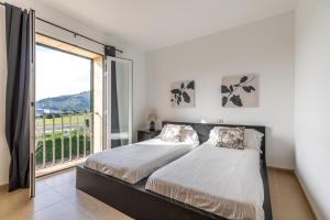 a bedroom with a bed and a large window at Spacious villa for 10 with private pool in El Port