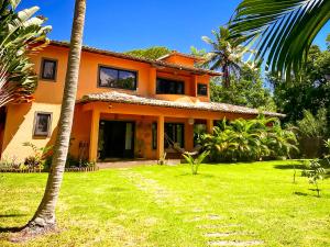 an orange house with a palm tree and a yard at Villa Beijaflor in Santo André