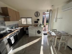 a kitchen with a washing machine and a table at "Chambre" Chez Zabou in Carpentras