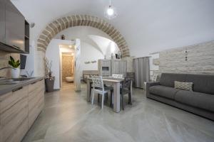 a kitchen and living room with a table and a couch at La Lanterna in Giovinazzo