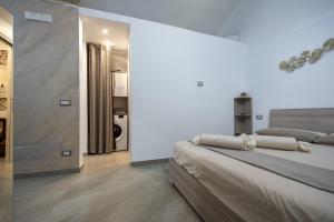 a white room with two beds and a bathroom at La Lanterna in Giovinazzo