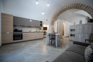 a living room with a kitchen and a table with chairs at La Lanterna in Giovinazzo +4 photos