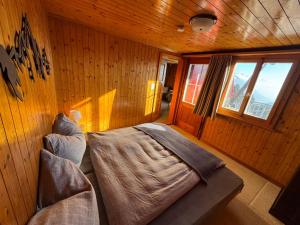 a bedroom with a bed in a wooden wall at Charming Chalet Silvretta in Flumserberg in Flums