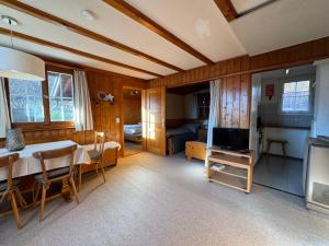 a living room with a table and a television at Charming Chalet Silvretta in Flumserberg in Flums