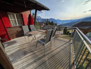 a balcony with two chairs and a table on it at Charming Chalet Silvretta in Flumserberg in Flums