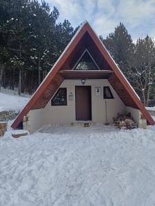 a house with a red roof in the snow at Planinska Kućica in Mostar +6 photos