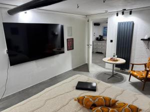 a living room with a large flat screen tv on the wall at Gemütliches Kellerzimmer + Bad in Bocholt