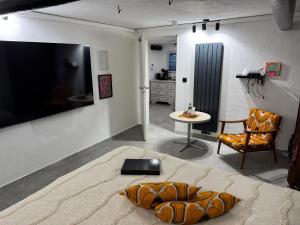 a living room with a large television and a table at Gemütliches Kellerzimmer + Bad in Bocholt