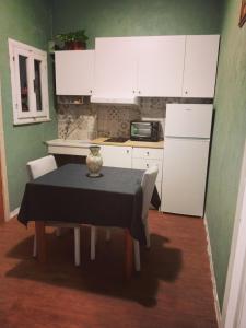 eine Küche mit einem Tisch und einem weißen Kühlschrank in der Unterkunft Rifugio del benessere in Monte Compatri