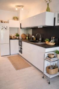a kitchen with white cabinets and a sink and a refrigerator at Petite Perle by Port Azur Rental in Cogolin