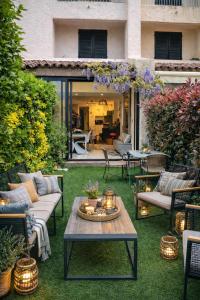 a patio with a table and chairs on the grass at Petite Perle by Port Azur Rental in Cogolin