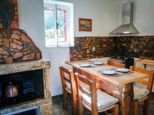 a kitchen with a wooden table and a fireplace at Armaki in Páliros