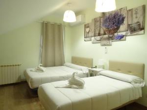 drei Betten in einem Zimmer mit weißen Wänden in der Unterkunft Brezo 2 in Yunquera de Henares