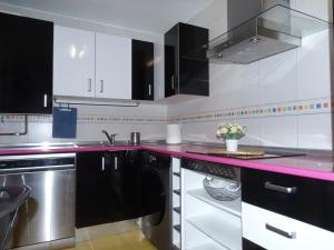 eine Küche mit weißen Schränken und einer rosa Arbeitsplatte in der Unterkunft Brezo 2 in Yunquera de Henares