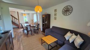 a living room with a couch and a clock on the wall at Polna Zagroda - domek do wynajęcia in Kielce +37 photos