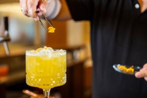a person is stirring a drink with a spoon at Beohotel in San Lorenzo in Banale +22 photos