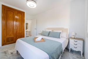 a bedroom with a bed with a wooden box on it at Apartamento isabel golf center in Almería +37 photos